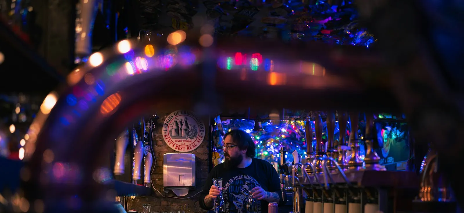 Comptoir du Boleston éclairé en fin de soirée, bouteilles alignées derrière le bar